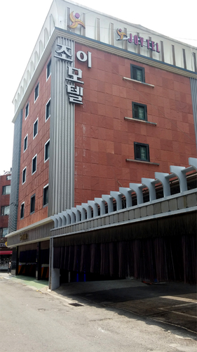 조이모텔 간판이 부착된 건물 외벽과 주차장 입구 가림막